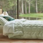 bed with a bed cover in a lighter color